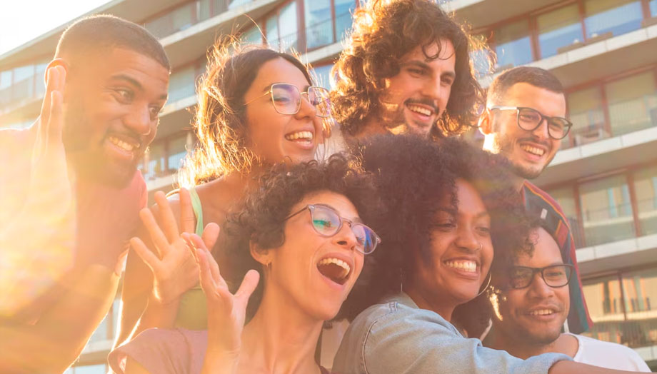 Fotografía grupal de personas de distintas razas sonriendo a la cámara